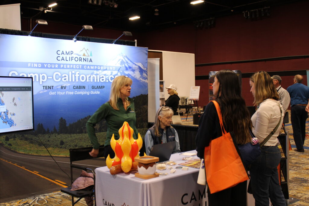 Camping booth with people discussing information.